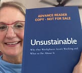 Photo of Nance L. Schick holding an Advance Reader Copy of UNSUSTAINABLE