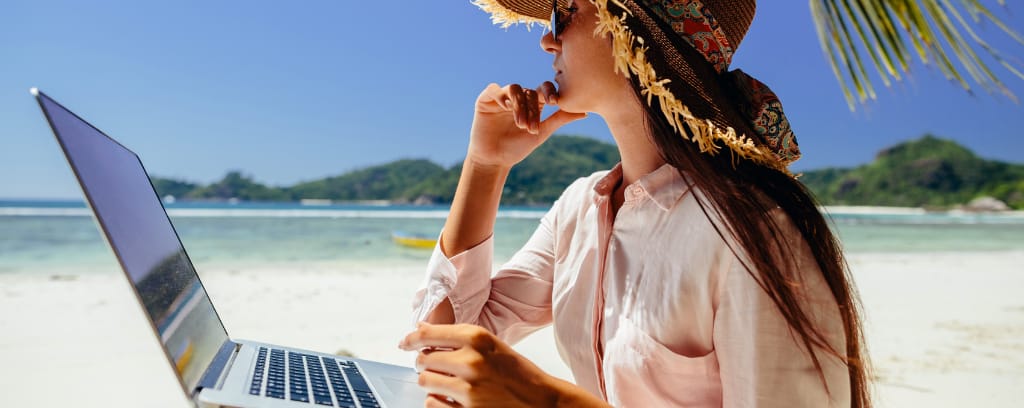 Photo of freelancer working on laptop from beach