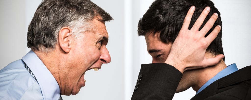 Photo of person yelling at another who tries to cover ears and protect himself.