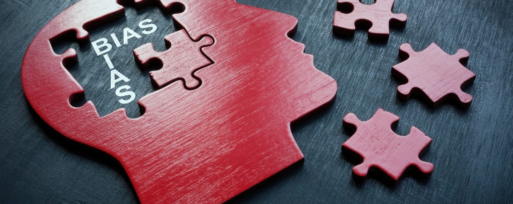 Photo of puzzle in the shape of human head with pieces removed to reveal the word bias