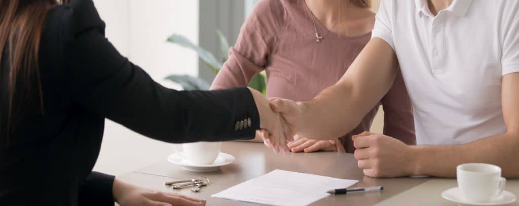 Photo of two clients shaking hands with their attorney.