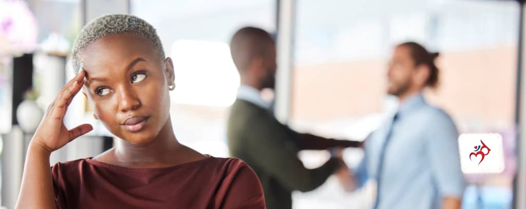 Photo of female worker annoyed by male co-workers shaking hands