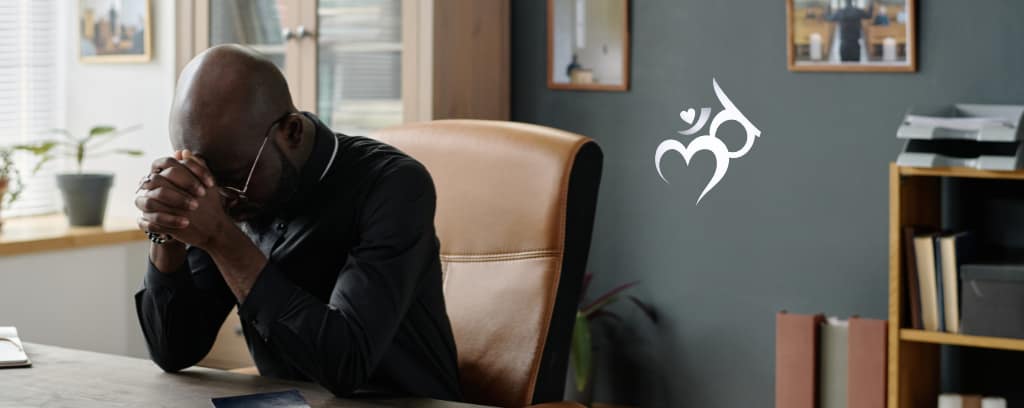 Employee searching for answers with head down and resting on folded hands