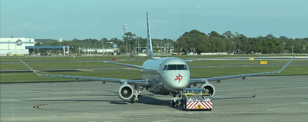 Photo of small tug vehicle pushing an airplane