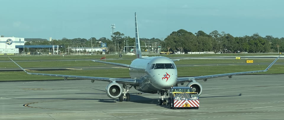 Photo of small tug vehicle pushing an airplane