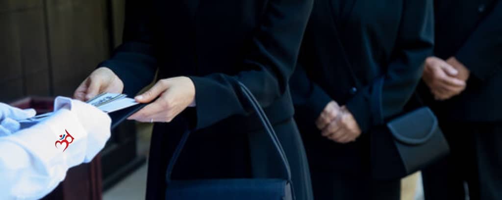 Photo of people at a funeral exchanging documents
