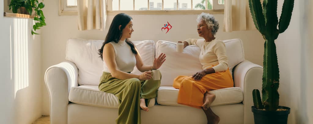 Photo of two people sitting on a comfortable sofa discussing a conflict over coffee