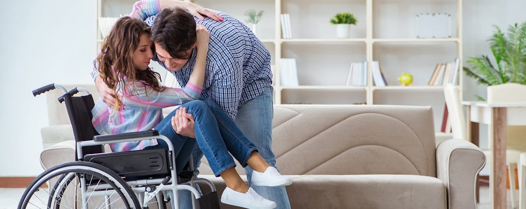 Photo of man helping woman in wheelchair