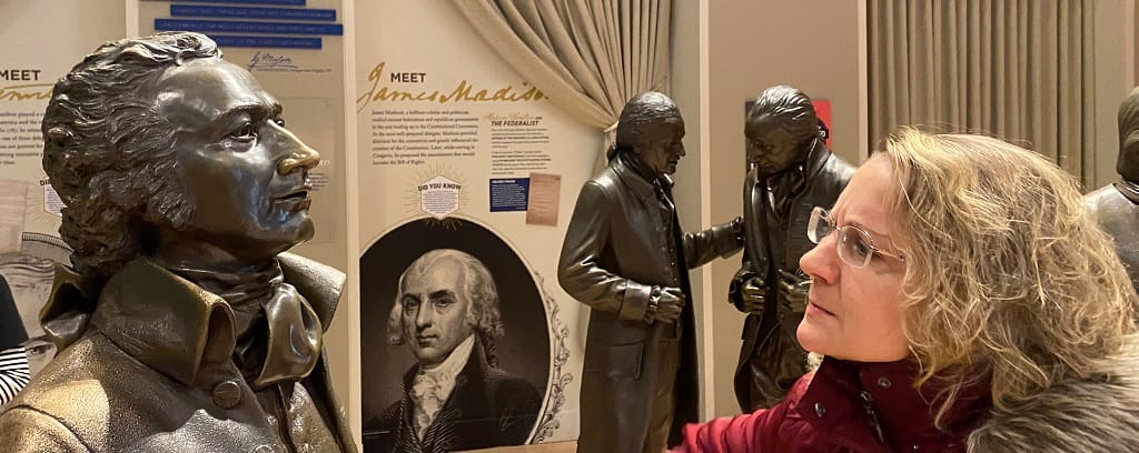 Photo of Nance L. Schick facing a statue of Thomas Jefferson, confused by his failure to give rights to ALL men--and women