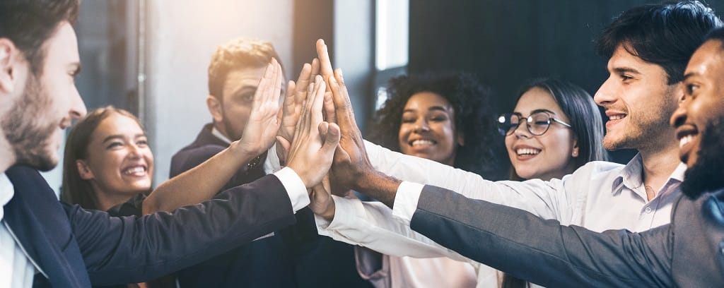 Diverse group of people in business clothes smiling and giving high-five signs with their hands