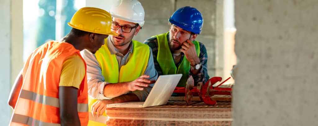 Photo of construction supervisor and foreman explaining policies to employee.